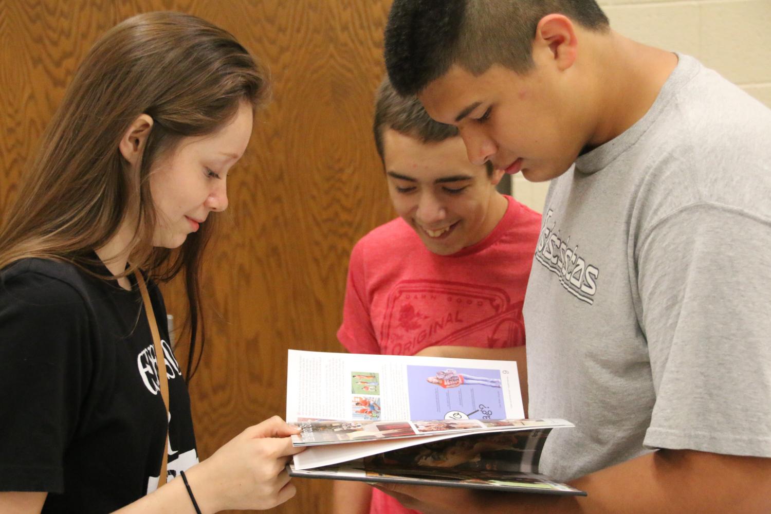 Destiny Martin, Jordan Rauh and Devin Blood look through their yearbooks to find themselves. 