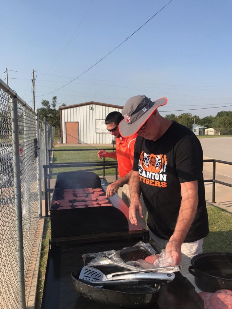 Coach Baldwin and Coach Rich cook up great food for the athletics tailgate. 