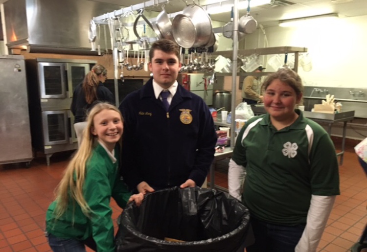 Amanda Schoonmaker, Nate Lang, and Emma Hoffman cleaning up after the auction.