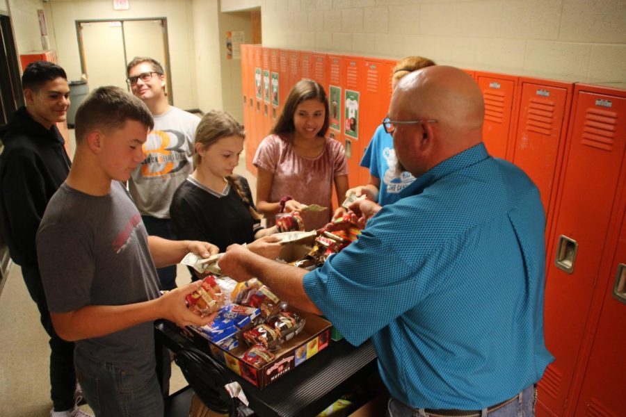 Mr. Barney selling students snacks.